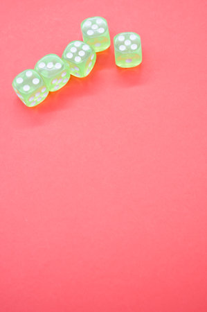 A top view closeup of five neon green dice isolated on a bright pink backgroundの写真素材