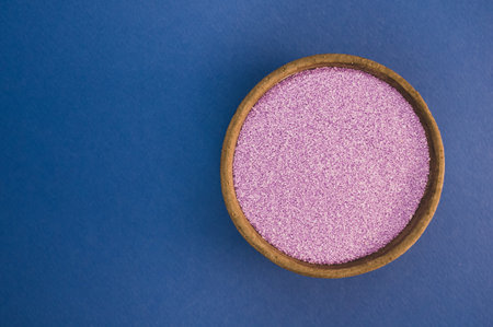 A shot of colored violet sand in a bowlの写真素材