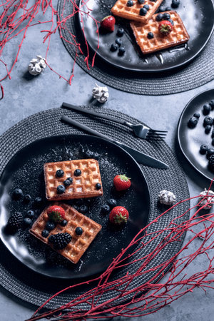 A vertical shot of waffle with berries in a plateの写真素材