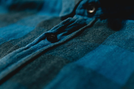 A closeup of a dark blue flannel shirt under the lights