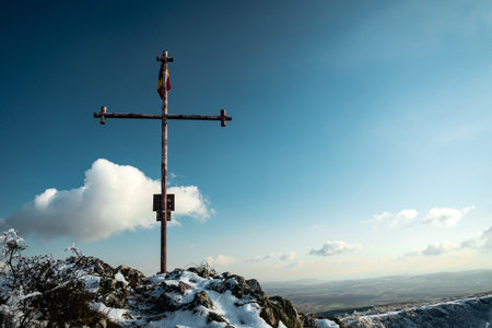 A Christian metal cross standing on the rock with a flagの写真素材