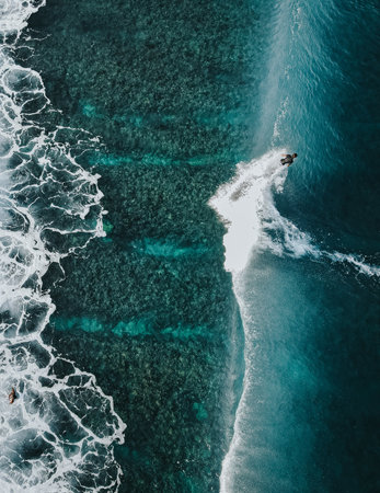 Surfing on blue waves in Maldivesの写真素材