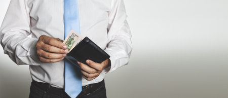 A closeup shot of male hands holding an open leather wallet with money - concept of finance success