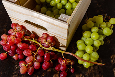 A closeup shot of fresh grapes in a wooden box in a food marketの写真素材