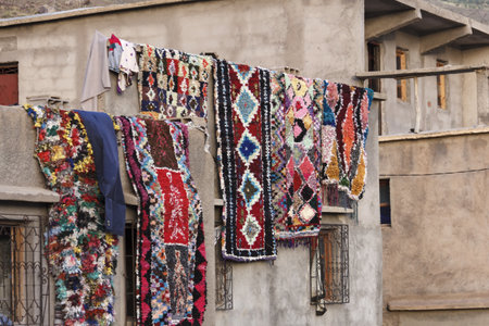 The colorful carpets drying while hanging on the wallの写真素材