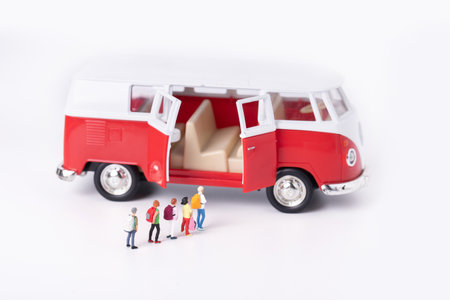 A closeup shot of figurines of students next to a miniature toy van