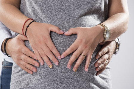 A closeup shot of a husband holding his pregnant wifeの写真素材