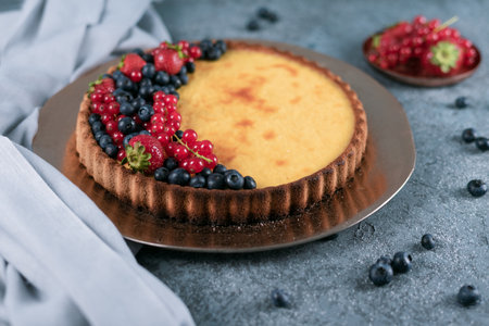A delicious pie with berries on a grey table