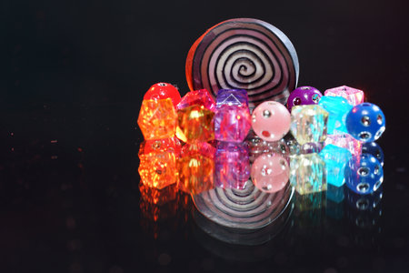 A closeup of colorful beads for making accessories on a black background