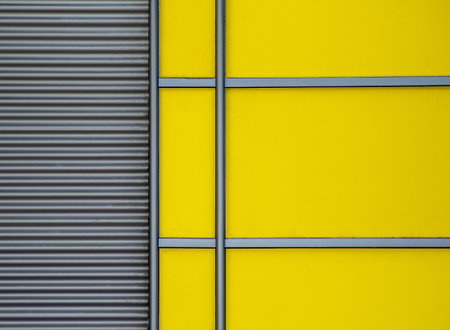 A minimalist shot of a yellow wall with metallic details