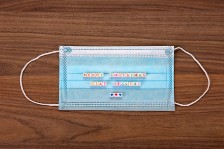 A face mask that says in German -Merry Christmas, Stay Healthy - concept of Christmas during pandemicの写真素材