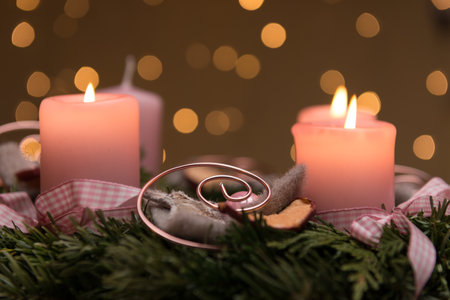 A closeup shot of burning candles in advent wreath with bokeh backgroundの写真素材