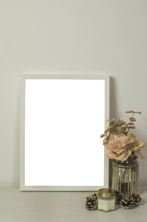 A vertical shot of an interior design of a living room with a white-framed poster with decorative...