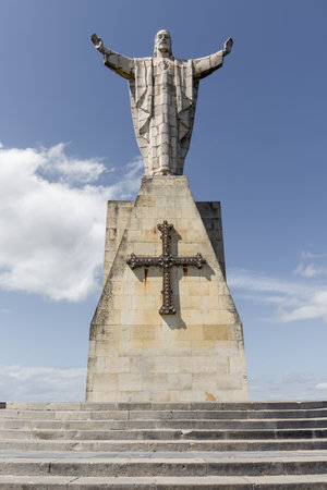 A vertical shot of the Monument to the Sacred Heart of Jesus against a cloudy blue sky in Oviedo, Asturias, Spainの写真素材