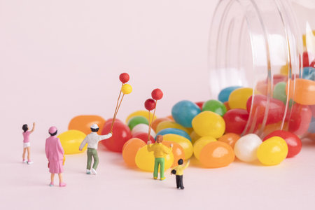 A closeup shot of people figures with balloons and colorful candies - concept of children's dayの写真素材