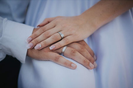 The hands of a just married couple with wedding rings