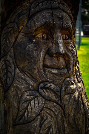 A closeup of a tree stump carved with an old manâ€™s face