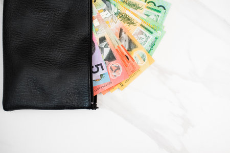 the Australian dollar banknotes in a black wallet on the white background