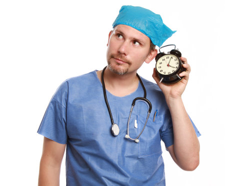 A doctor holding up a clock  isolated on a white backgroundの写真素材