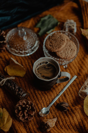 A vertical shot of tasty cookies and coffee in an autumn decoration setの写真素材