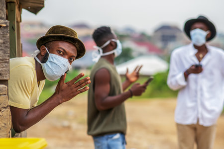 A young black man undergoing digital detoxing-millennial wearing face mask for protection during covid-19 - concept on practicing social distancingの写真素材