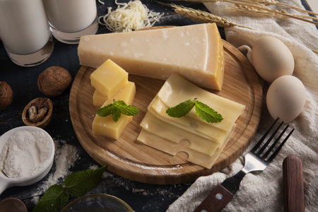 A top view of a delicious cheese platter with milk, flour, and eggs on a table