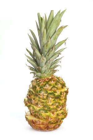 A vertical shot of a cut pineapple with stacked pieces isolated on a white backgroundの写真素材