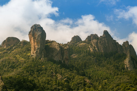 A beautiful shot of high mountains and hills covered by greenery on a sunny dayの写真素材