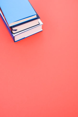 A closeup  of the hardcover books on the red surface - space for textの写真素材