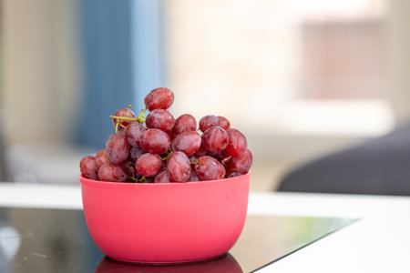 A closeup shot of the juicy red grapes in the bowl