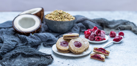 A closeup shot of raw vegan cookies with coconut and raspberriesの写真素材