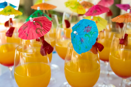 A closeup shot of orange cocktails with umbrellasの写真素材