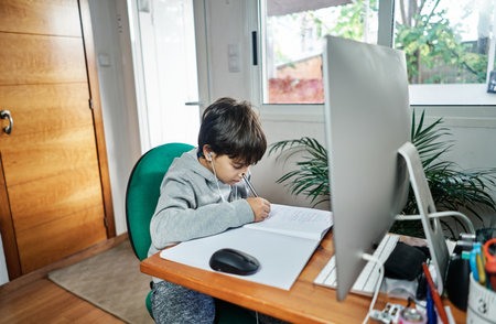 A Caucasian boy studying at home by a video conference because of the Covid19 - homeschooling