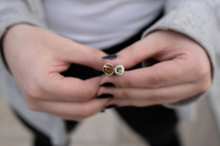 A selective focus shot of marijuana CBD and tobacco in female han