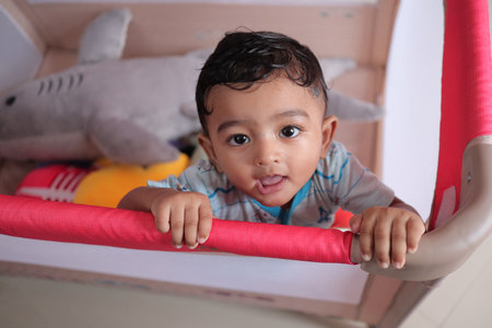 A shallow focus of an adorable Indian baby in a cradle in a room