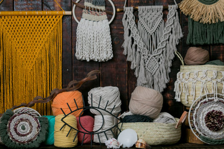 A closeup shot of baskets full of multicolored knitting wool balls and macrame hanging on the wall