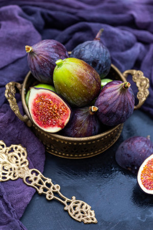 A closeup shot of purple and green fresh fig in a basketの写真素材