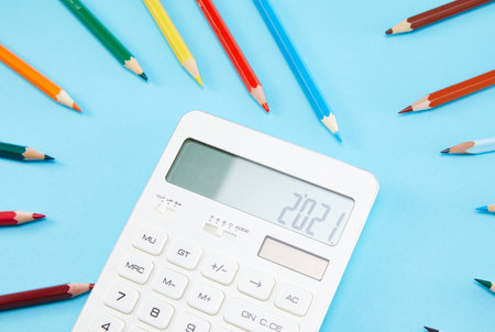 Happy New Year 2021 Colorful pencils and a calculator on a blue backgroundの写真素材