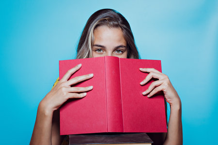 A closeup shot of a young lady holding a book - concept of education