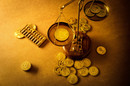 A high angle shot of a bitcoin and coins on scales on the table - concept of futurism and bankingの写真素材