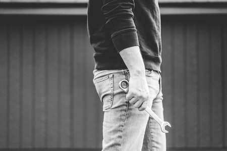 A grayscale shot of a technician holding a tool