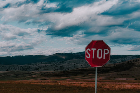 A closeup shot of a stop sign against a beautiful landscapeの写真素材