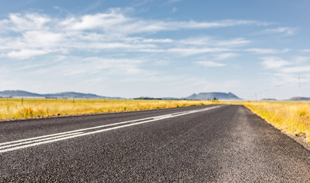 A selective focus shot of an asphalt road in a rural areaの写真素材