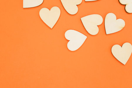 A top view of the wooden shaped hearts on the orange surface - space for textの写真素材
