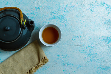 A top view of a gray teapot and a cup on blue backgroundの写真素材