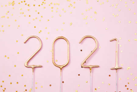 Happy New Year 2021 Golden numbers 2021 with shiny golden stars on a pink background