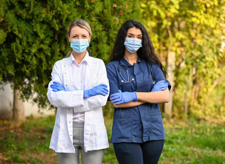 A shallow focus shot of doctors wearing face masks outdoorsの写真素材