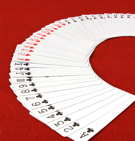 A closeup shot of a deck of playing cards fan spread isolated on a red background