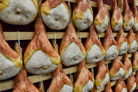 Typical italian raw ham hanged in rows perspective viewの写真素材