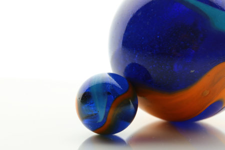 A closeup shot of two big and small balls with colorful textures on a white surfaceの写真素材